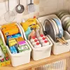 A off-white steel kitchen sink with a dish rack and a pot storage box details Picture